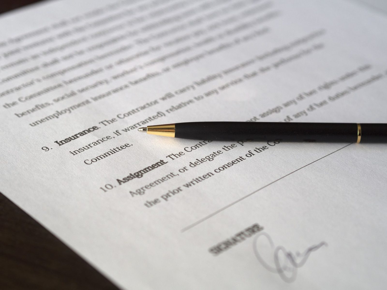 A close-up of a pen resting on a signed business contract, ready for agreement.