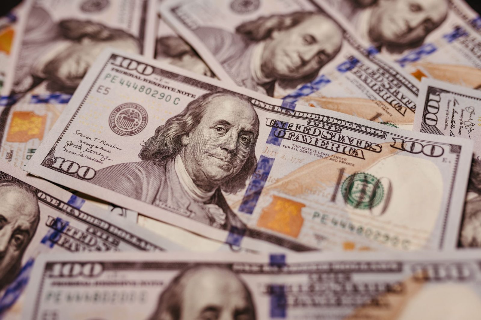 Fajo de billetes de cien dólares en primer plano, símbolo de dinero y éxito financiero.