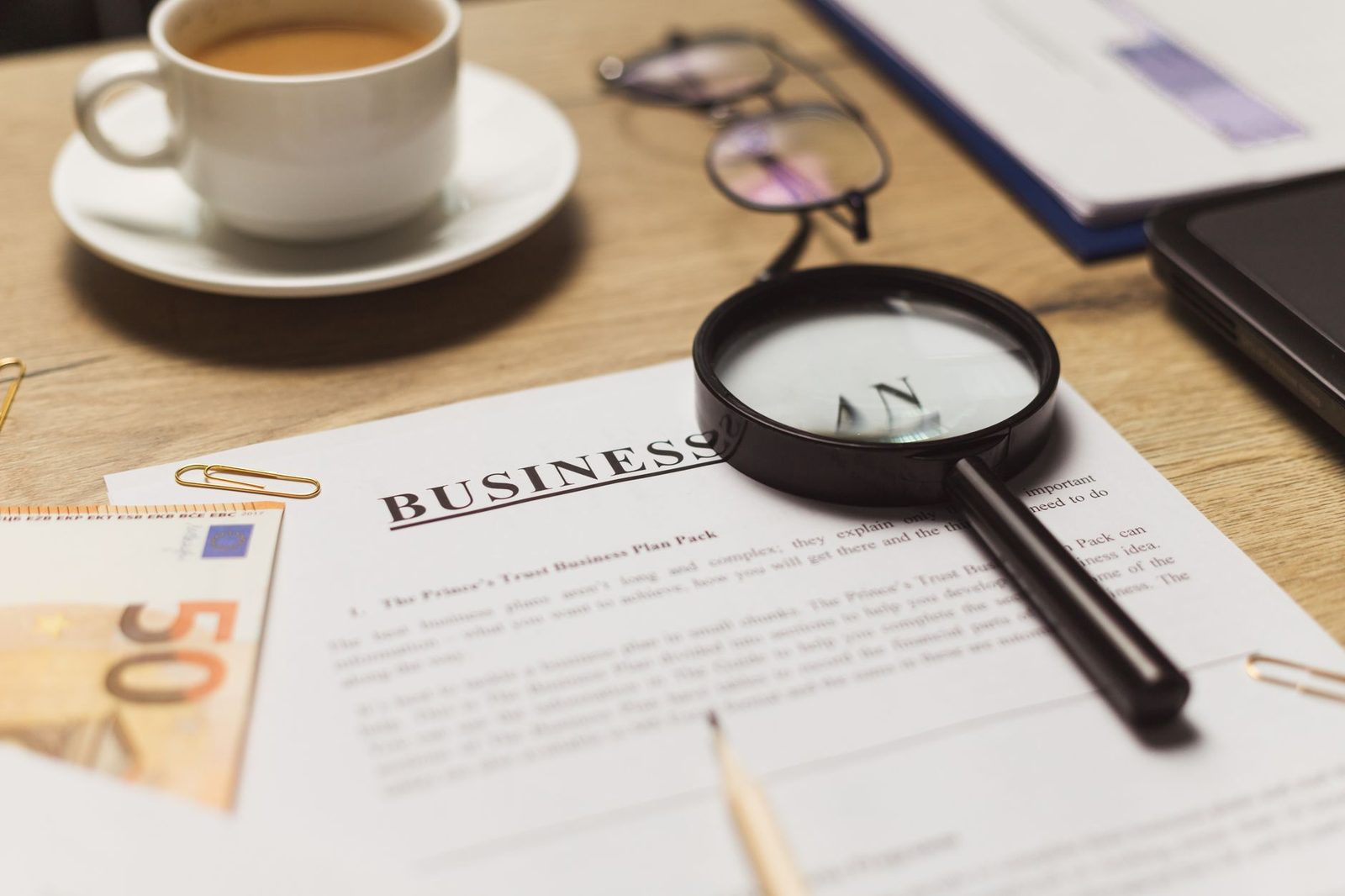 A desk with documents, a cup of coffee, and financial papers arranged for a business review.