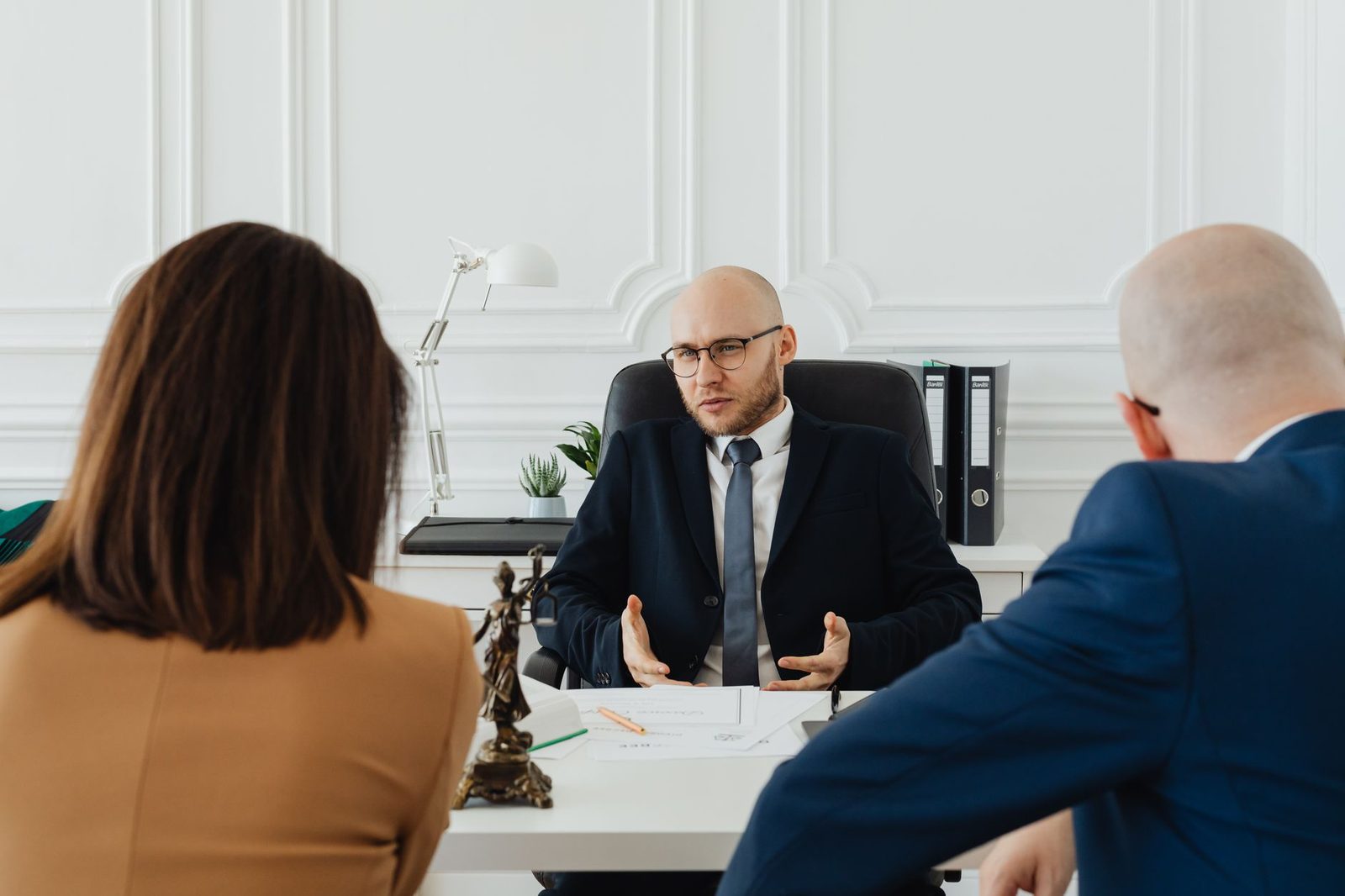 A lawyer and clients meet at a table in a modern office during a business consultation.