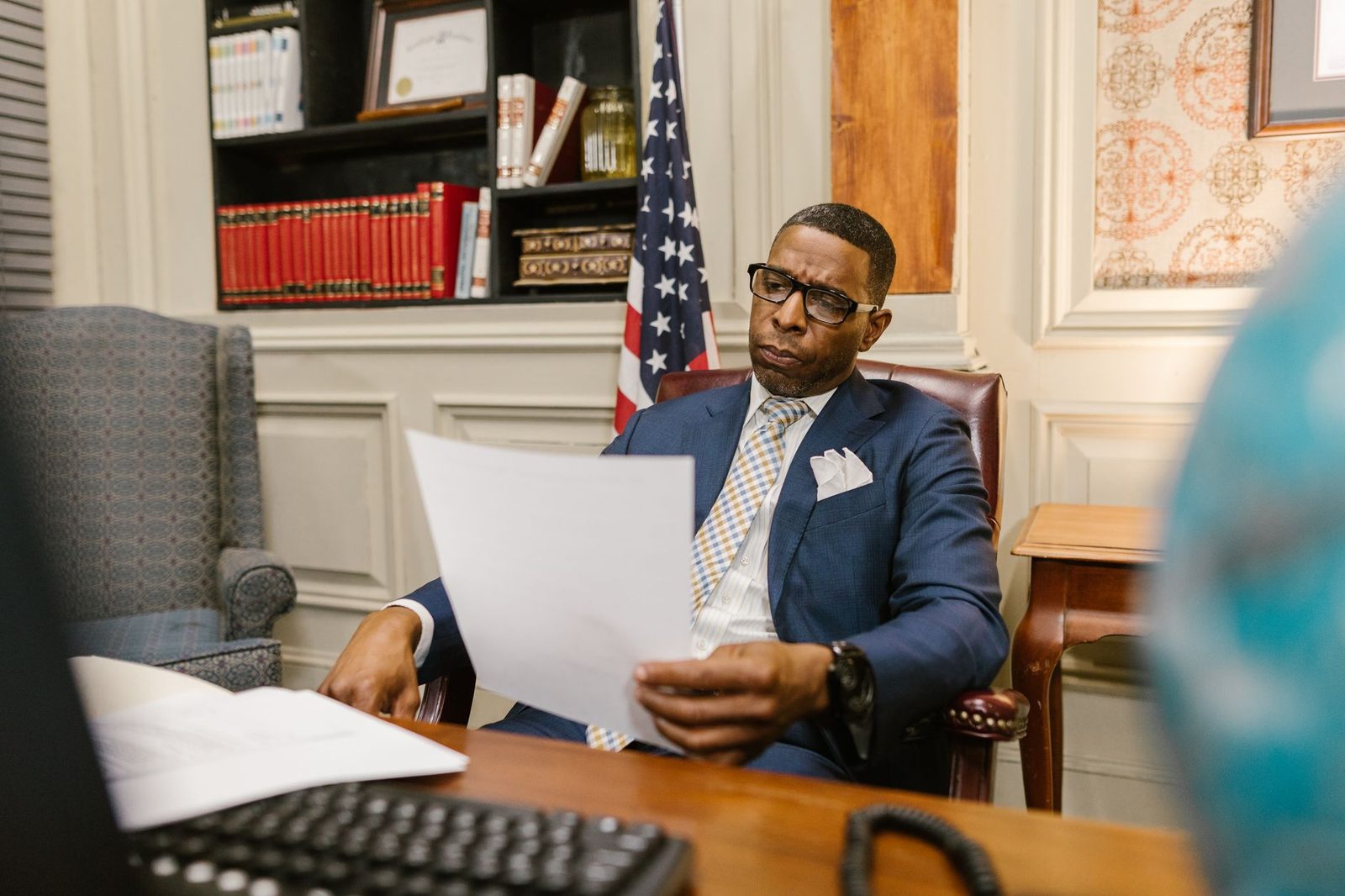 A lawyer reviews documents at a desk in a law office.