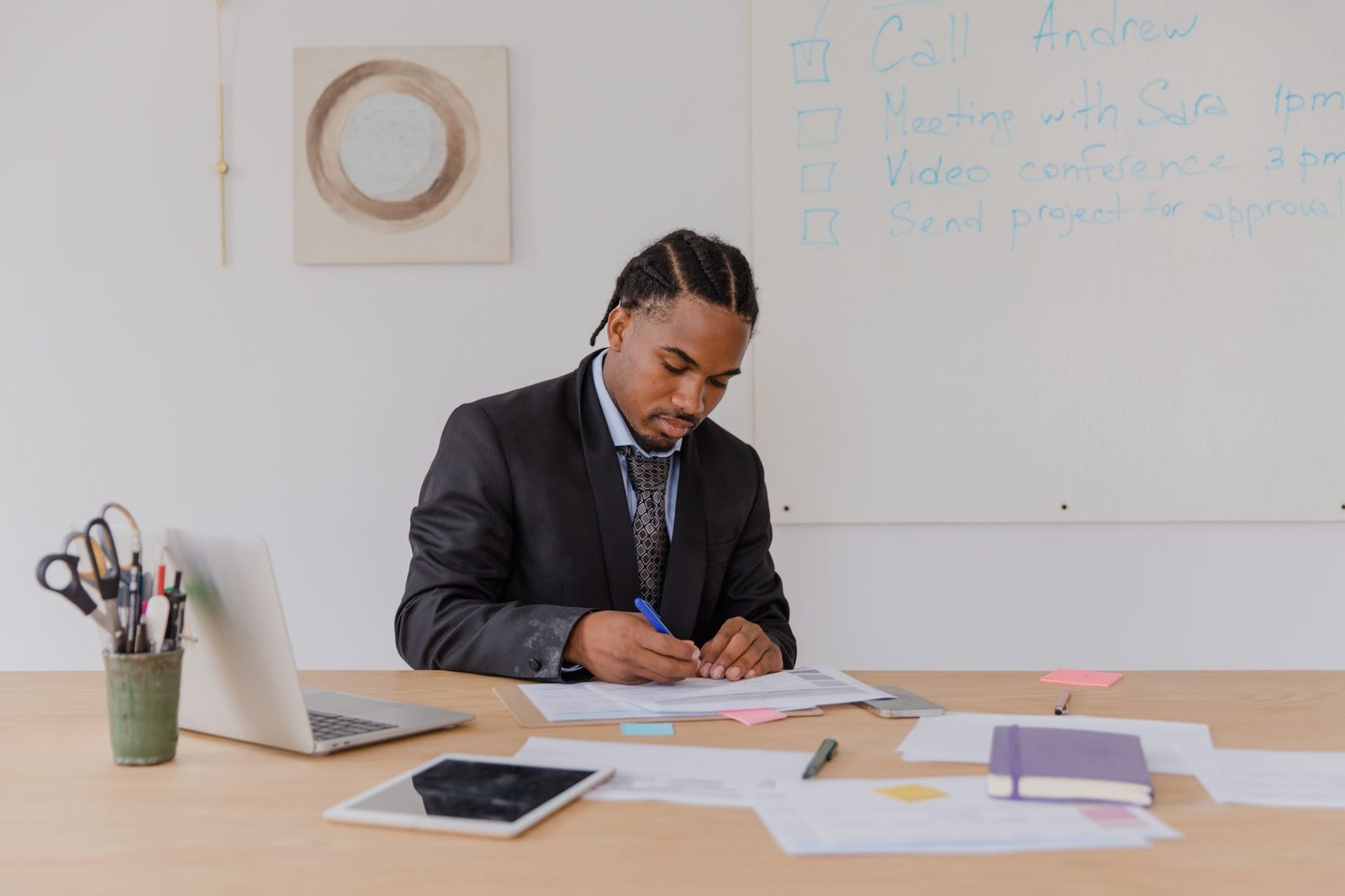 A professional man reviews documents at a tidy office desk.