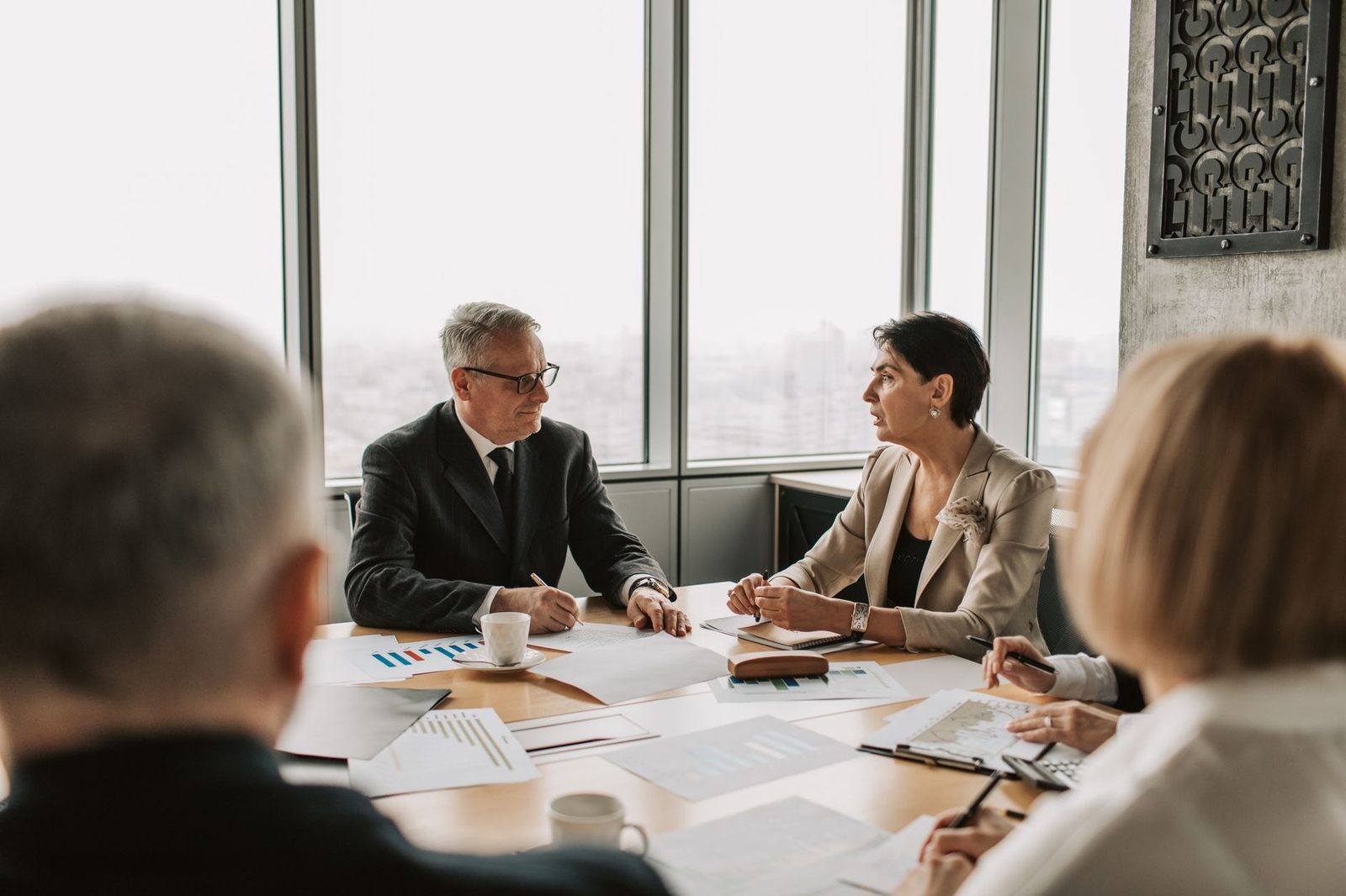 Profesionales de negocios reunidos alrededor de una mesa en una oficina moderna y luminosa.