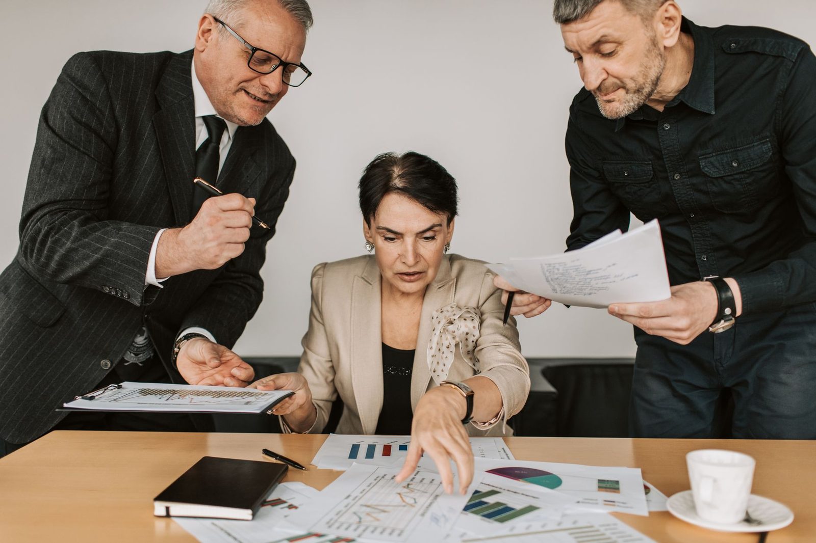 Business team discussing financial reports around a table during an office meeting.