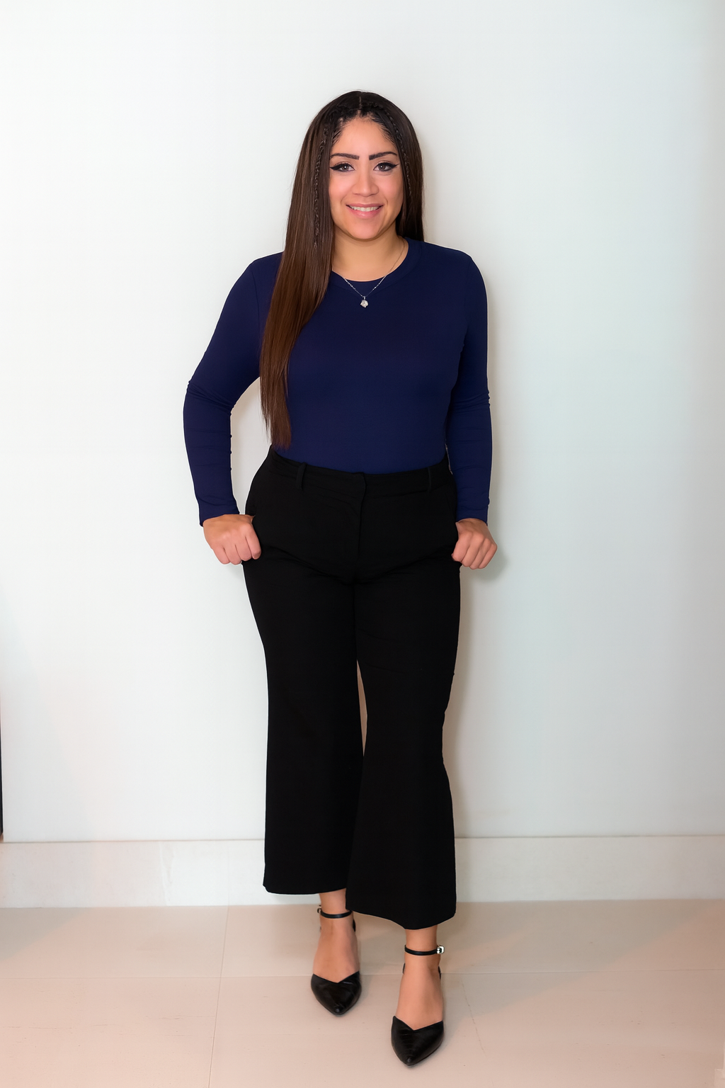 Woman smiling, wearing business casual outfit.