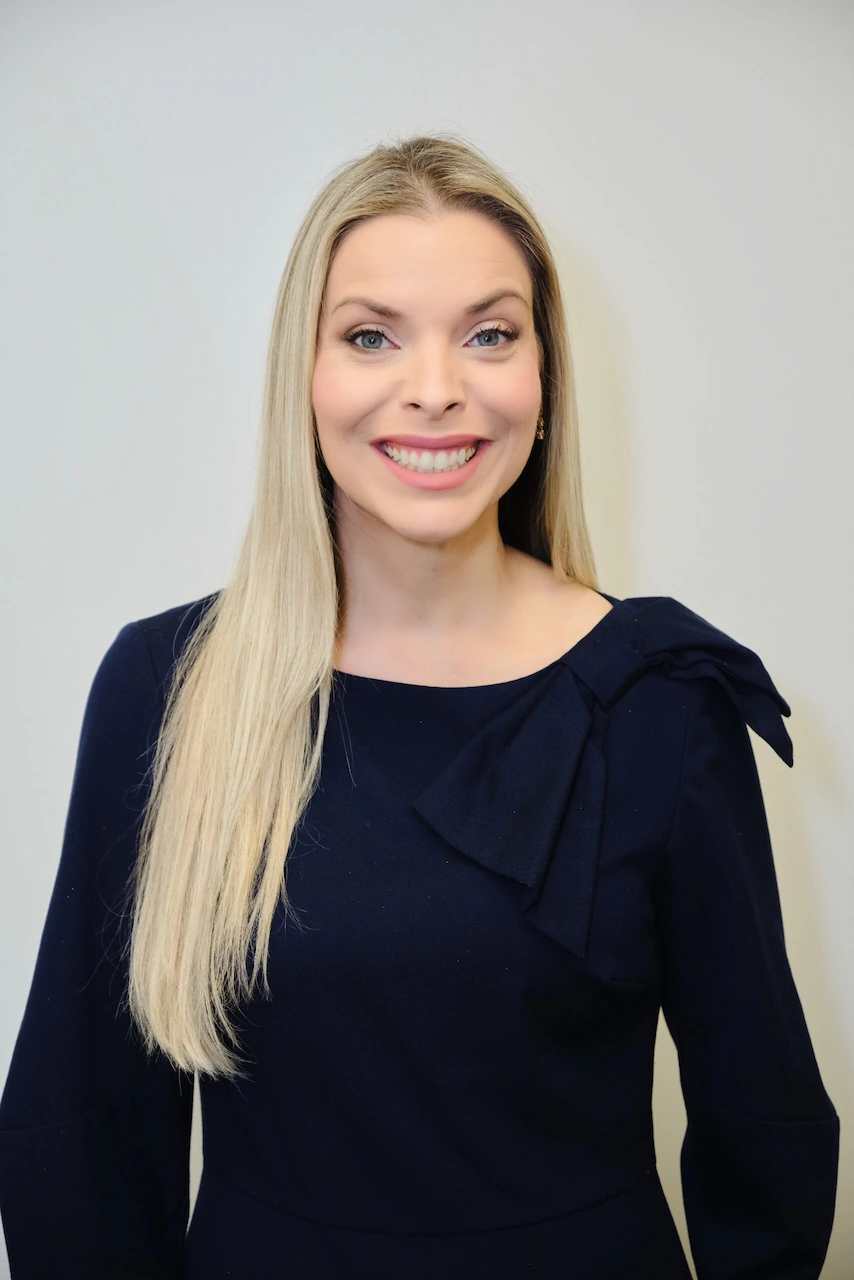 Smiling woman with long blonde hair in navy dress