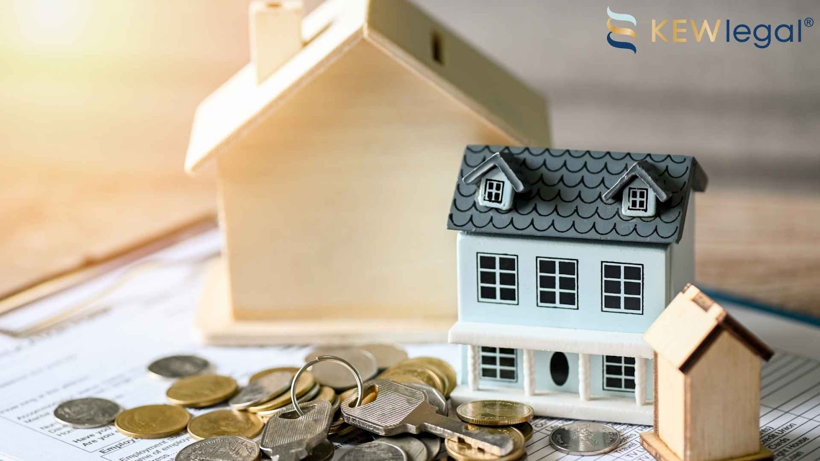 Model houses, coins, and key on documents