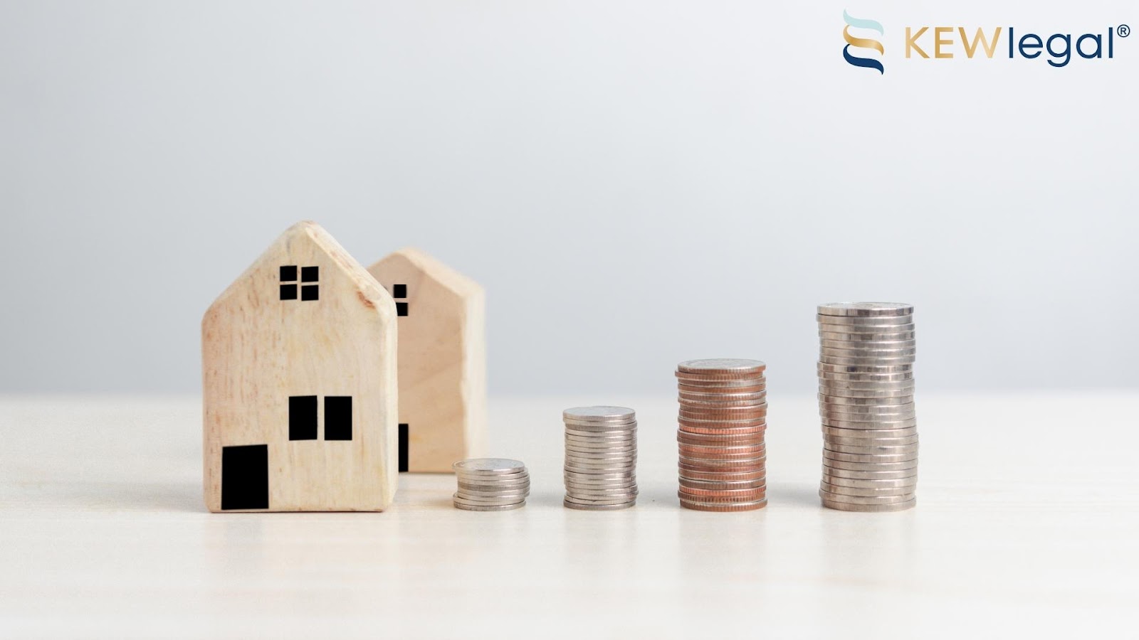 Model houses and stacked coins increasing in height.