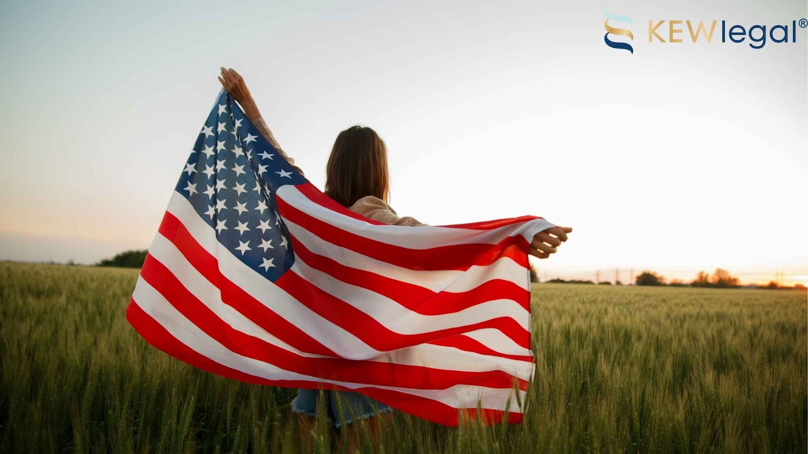 Person holding American flag in a field