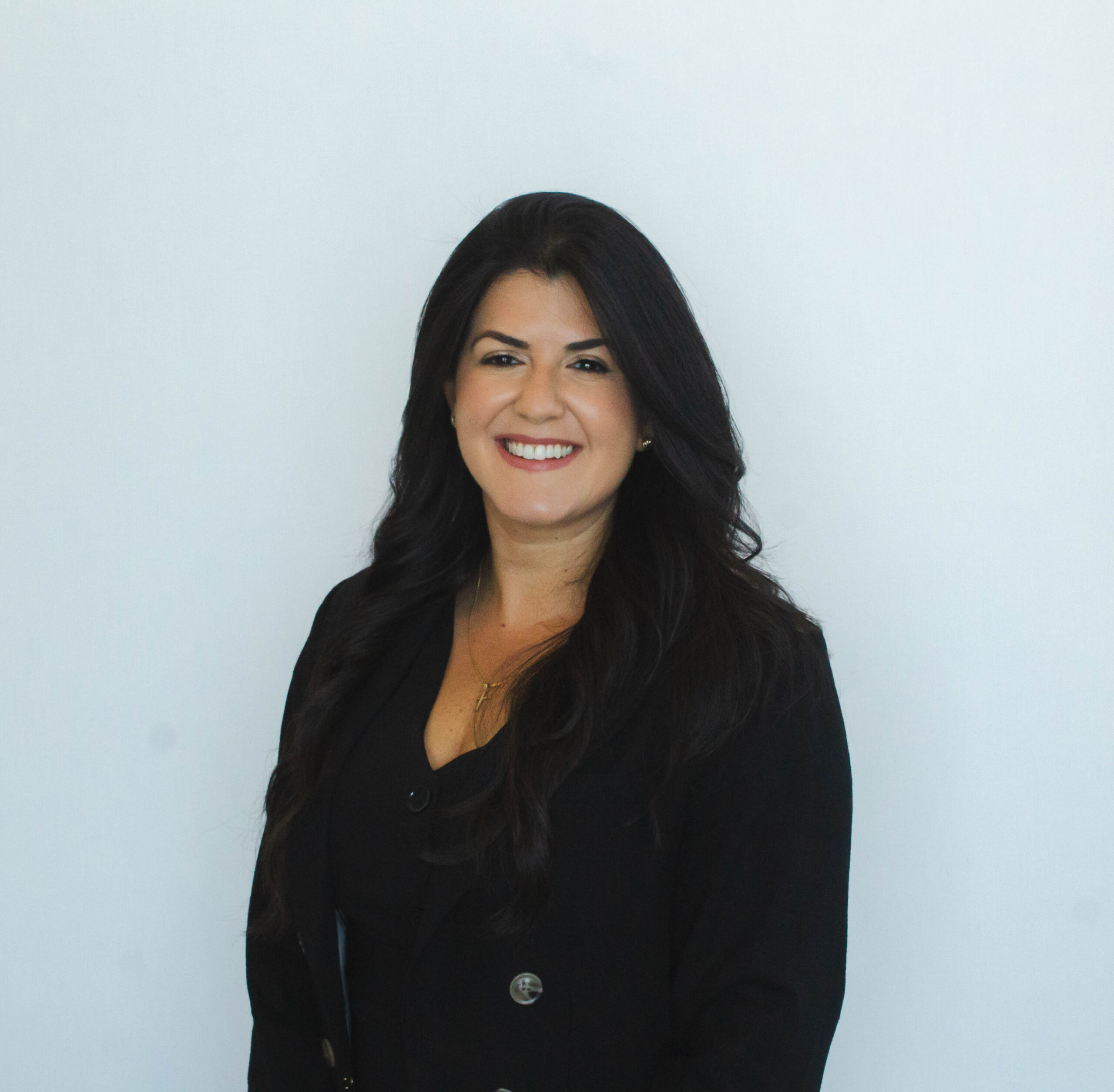 Smiling person in black outfit against white background.